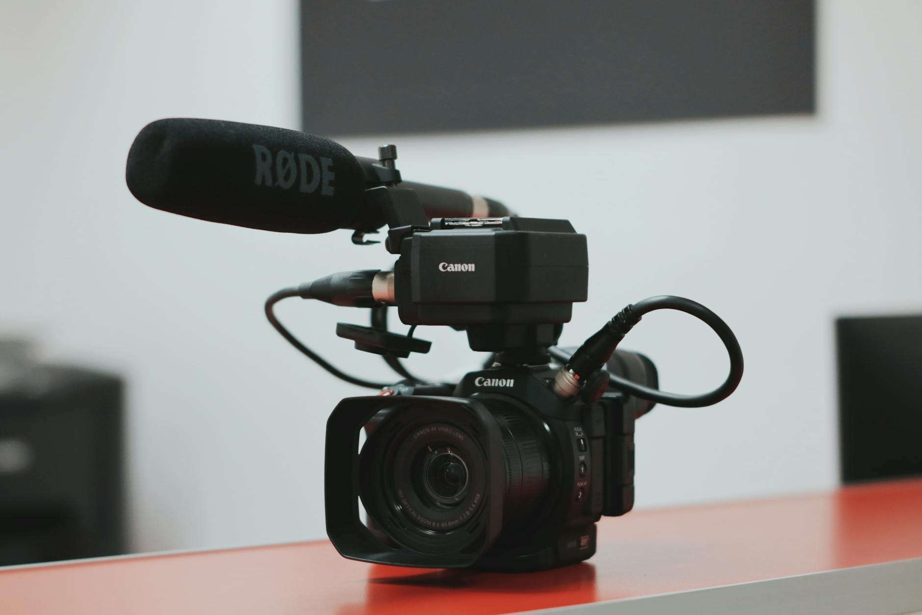 black canon video camera with microphone on desk